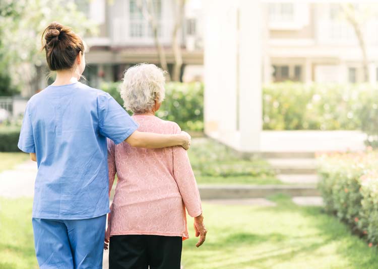 Pflegerin begleitet ältere Frau im Grünen © interstid - stock.adobe.com Pflegerin begleitet ältere Frau im Grünen