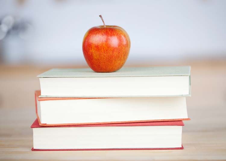 Apfel liegt auf einem Bücherstapel © contrastwerkstatt - stock.adobe.com Apfel liegt auf einem Bücherstapel