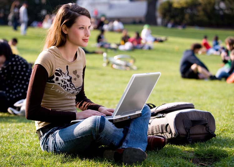 Junge Frau sitzt mit Notebook im Park © Franz Pfluegl - Fotolia.com Junge Frau sitzt mit Notebook im Park